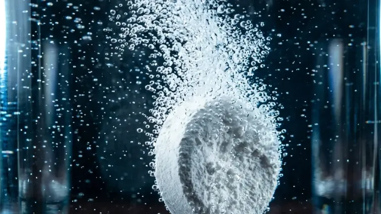 A biological treatment tablet dissolving in water, releasing oxygen micro-bubbles.